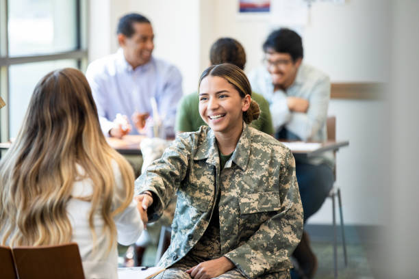 Young woman in military uniform smiles and shakes hands during a meeting
